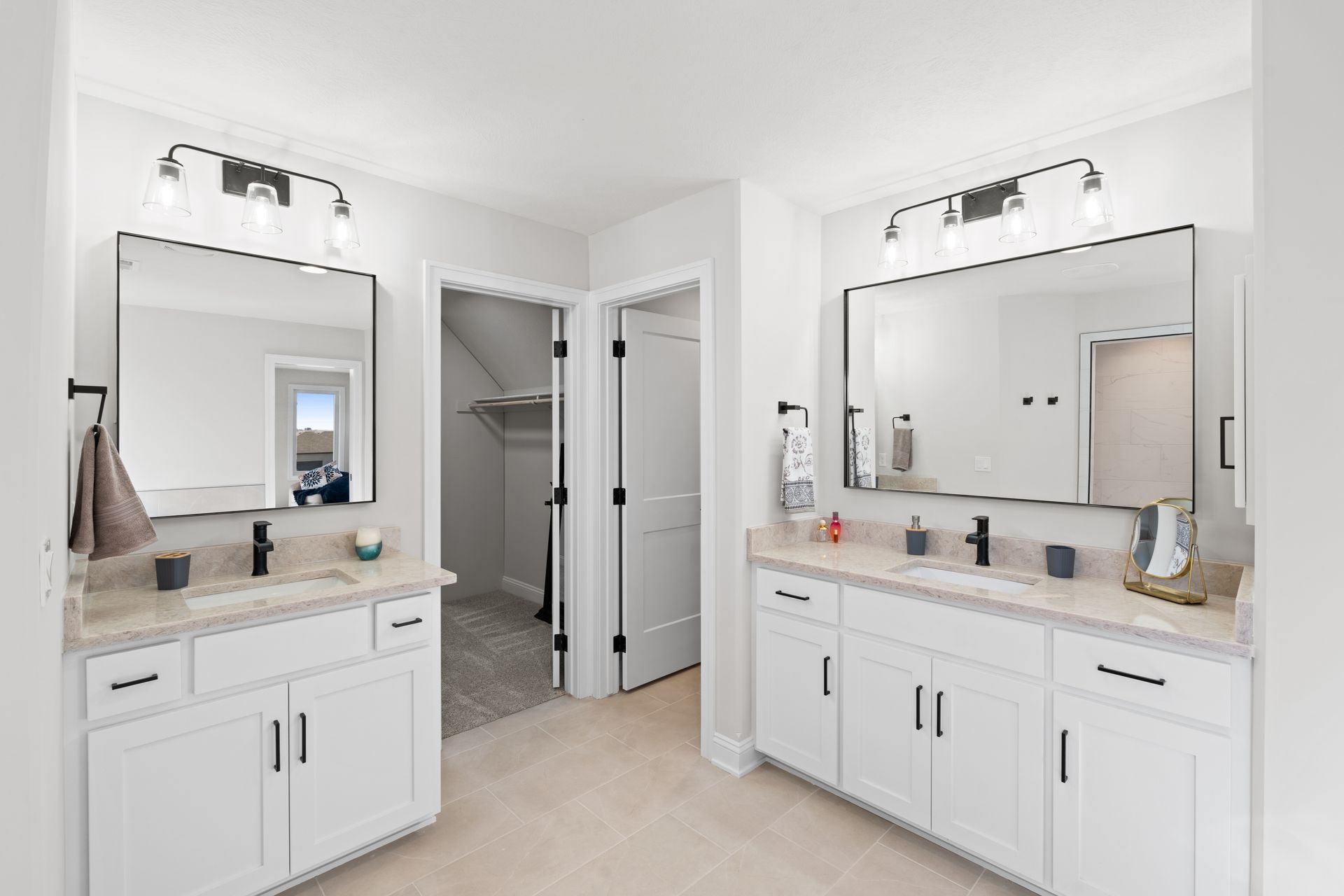 Bright bathroom with twin vanities, large mirrors, and a central walk-in shower