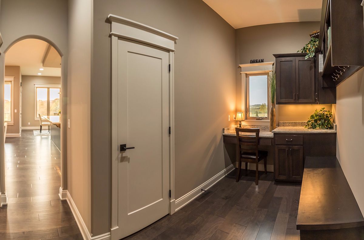 Small kitchen nook with dark cabinets, bar counter, and a hallway door in a modern home.