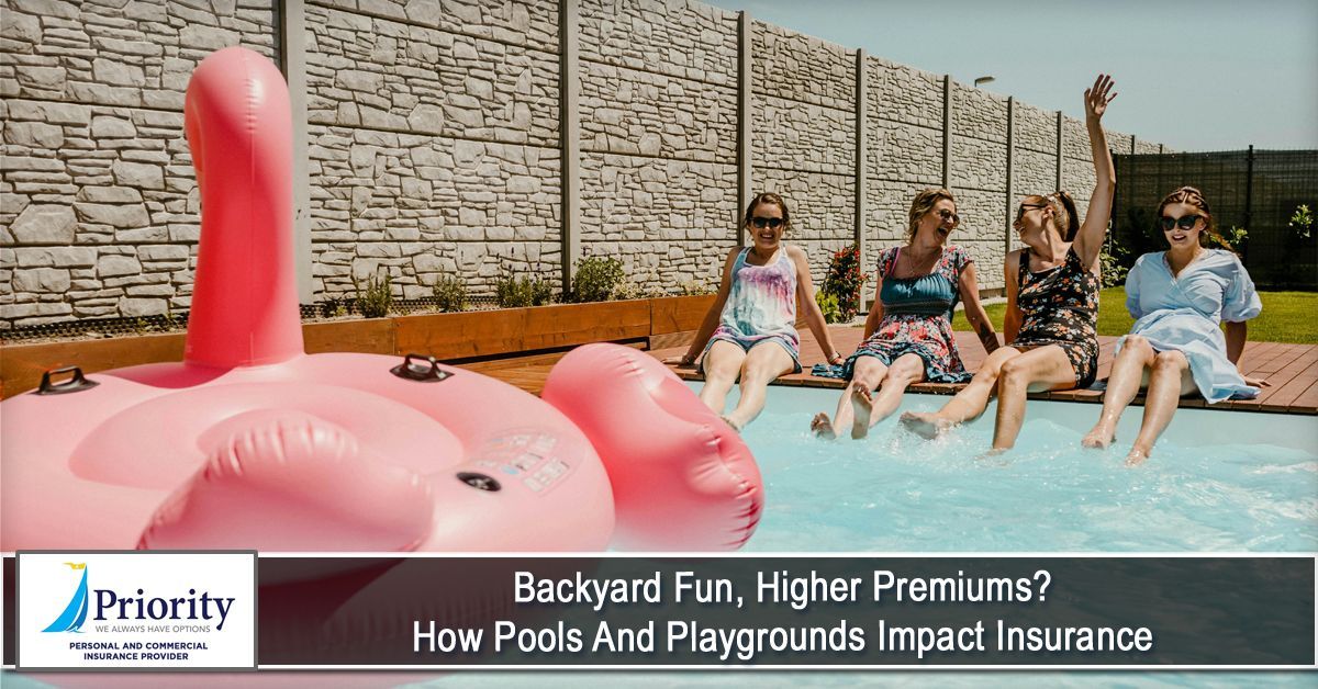 Four women sit on a pool edge with feet in the water, a pink flamingo float nearby.