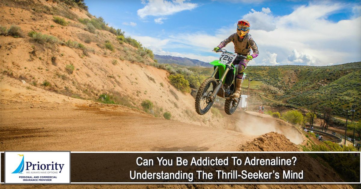 A motocross rider in mid-air, on a dirt path with a green bike.