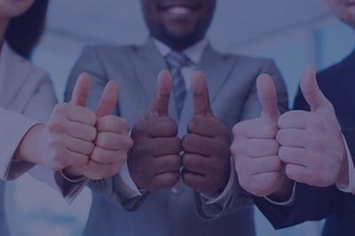 Three business people in suits giving thumbs up.