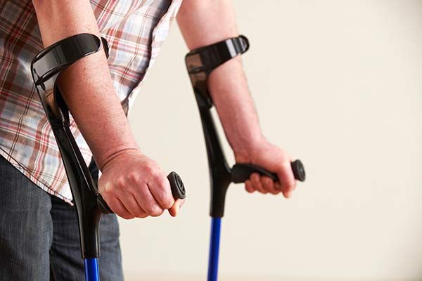 A man is using crutches to walk.