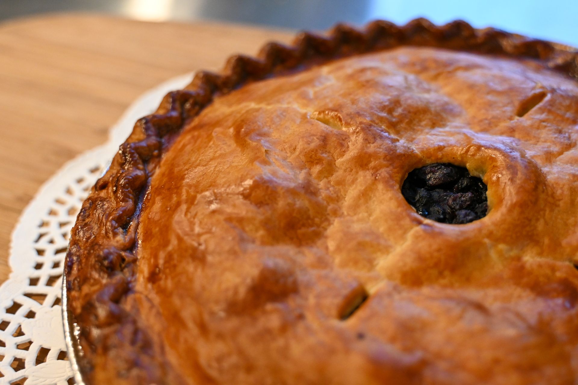 A close up of a pie with a hole in the middle on a table.