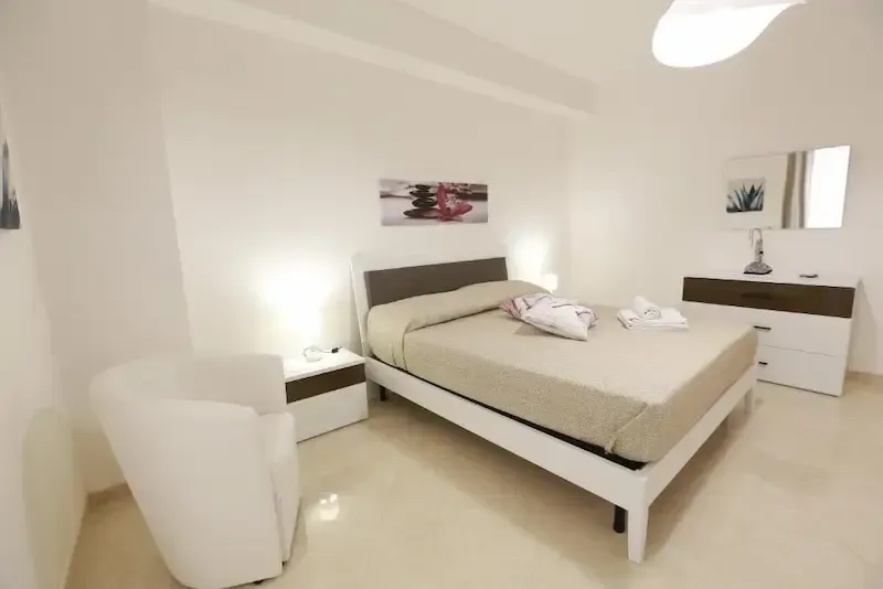 Bright modern bedroom with large bed and elegant decor in a Sicilian holiday home