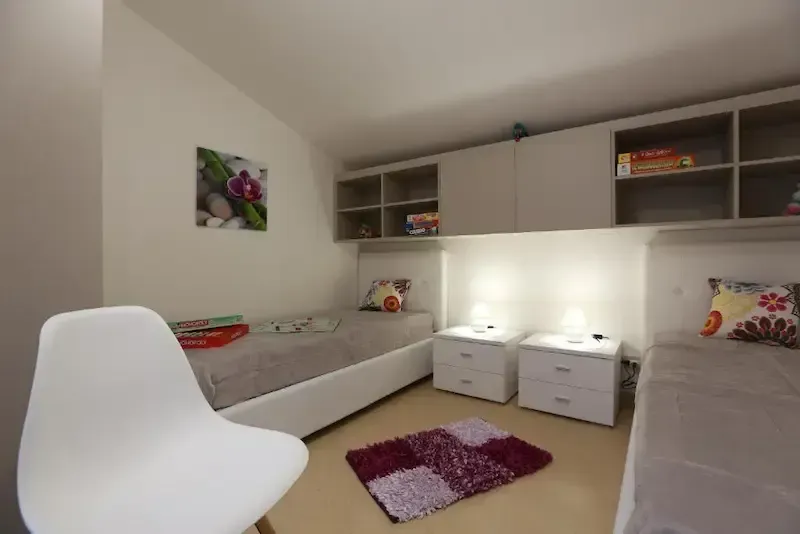Twin bedroom with shelves, board games and soft lighting