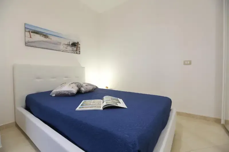 Modern bedroom with blue bedding and open magazine on the bed