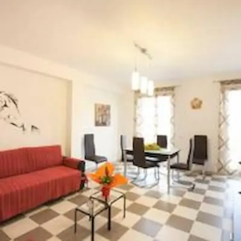 Casa Nina Pozzallo living and dining area with sofa and glass-top table