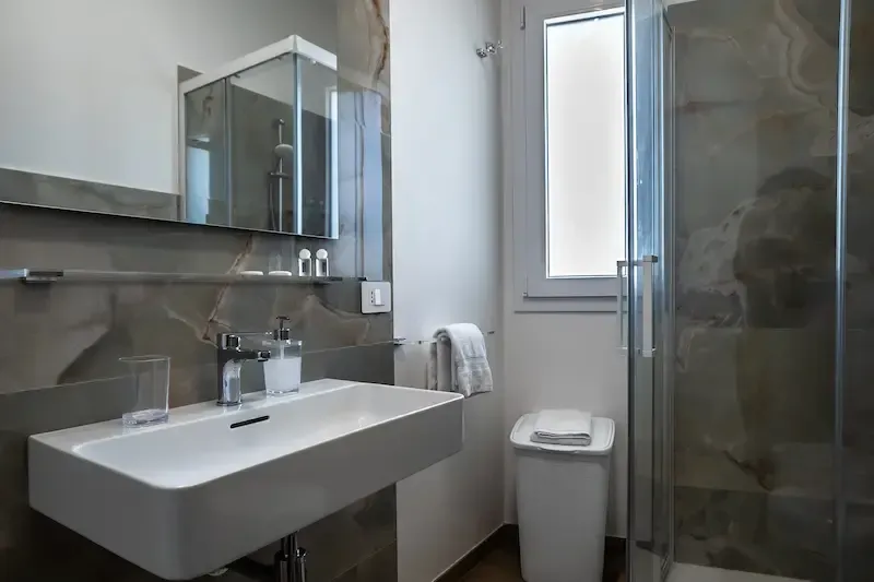 Modern bathroom with sink, mirror cabinet, toilet, and glass shower enclosure