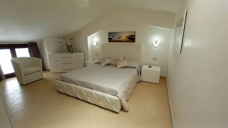 Bright double bedroom with beige decor and soft lighting