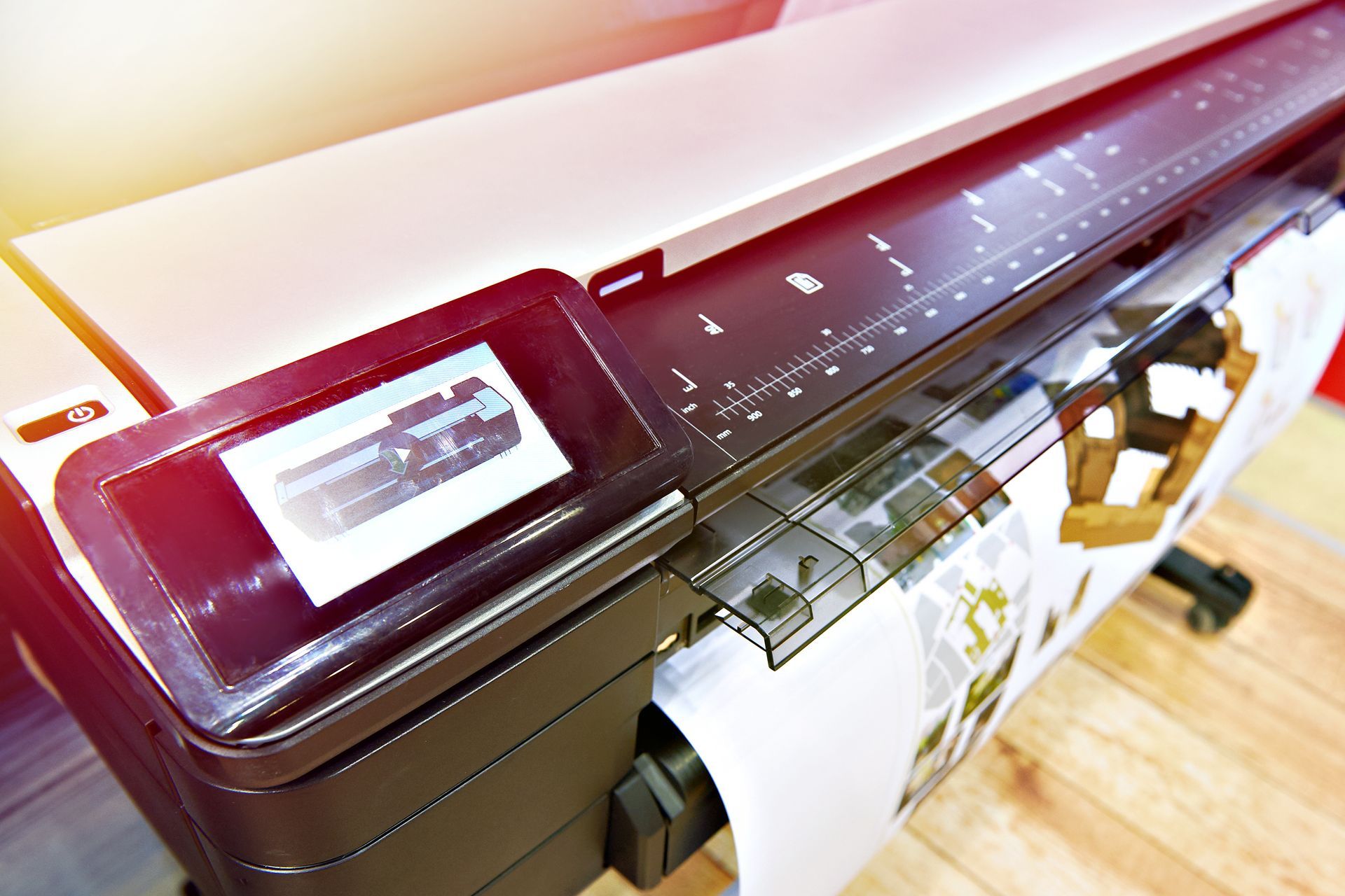 Large-format printer outputting a colorful poster in a workshop-like setting