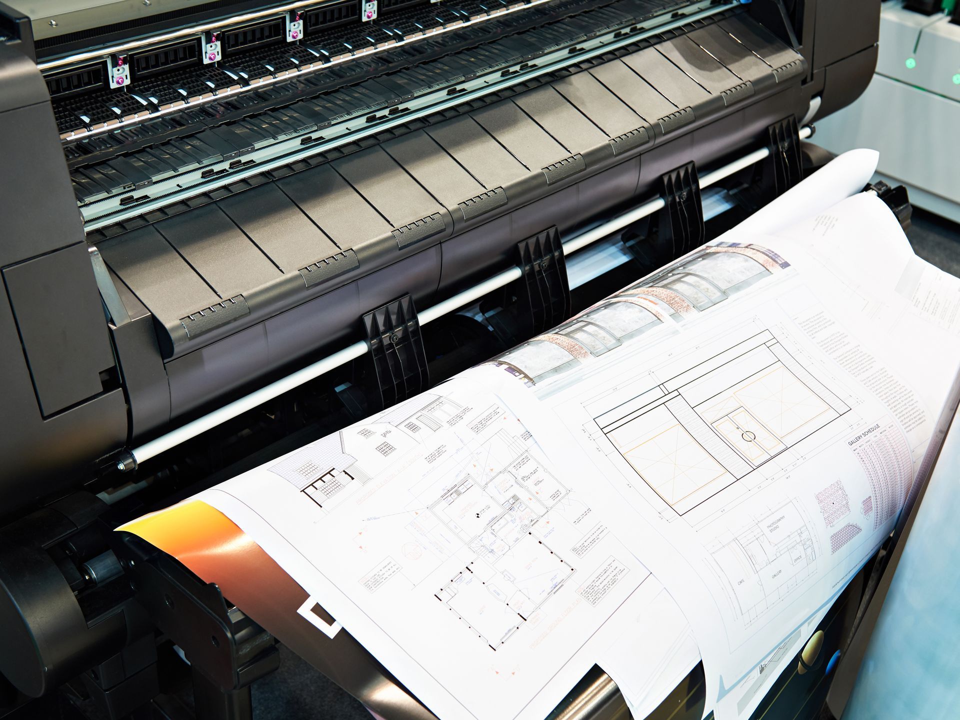 Large printer outputting technical blueprints on white paper
