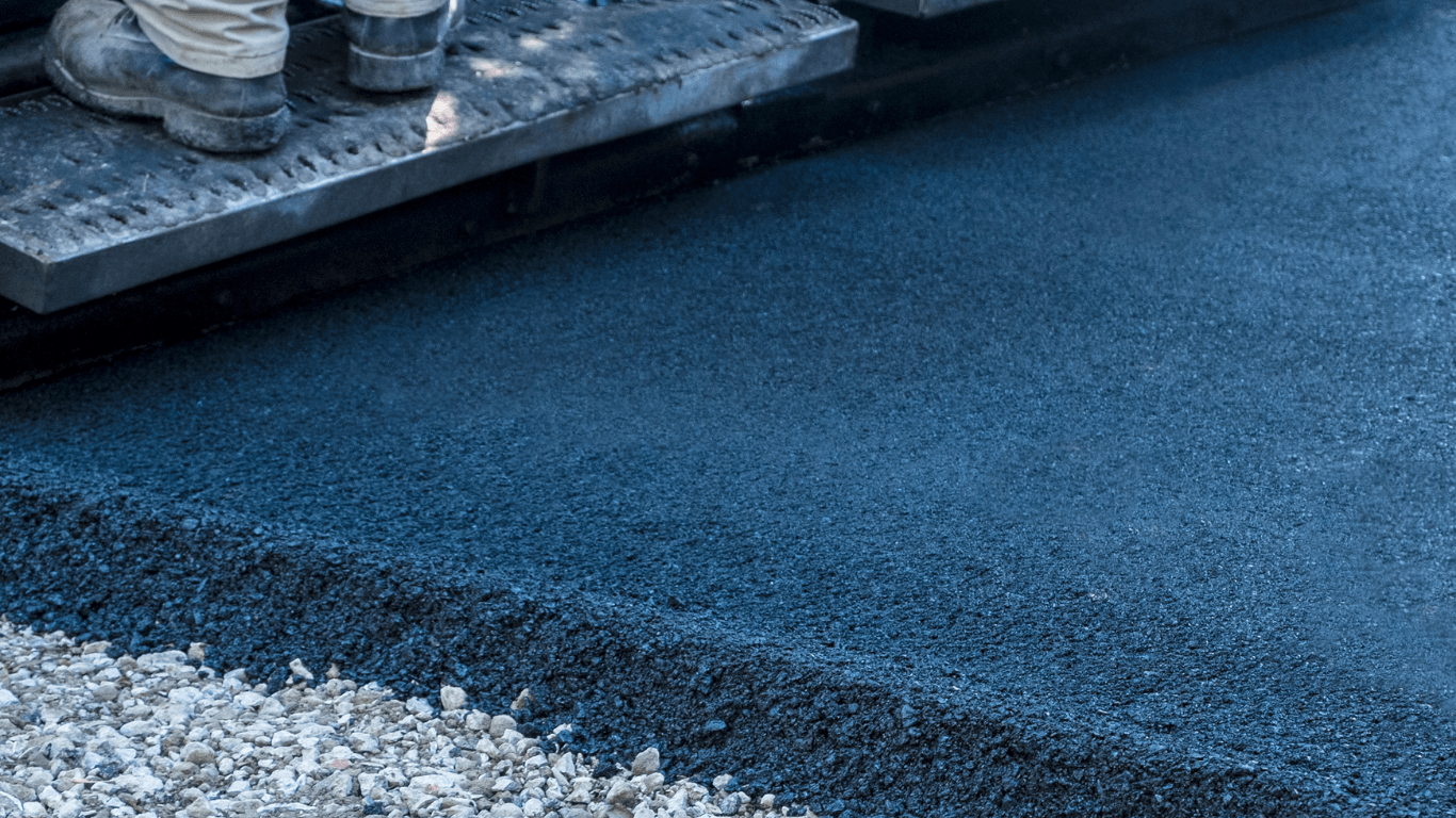 Close-up of freshly laid asphalt showing smooth texture and clean edge next to gravel during an asphalt paving service in Centennial, CO