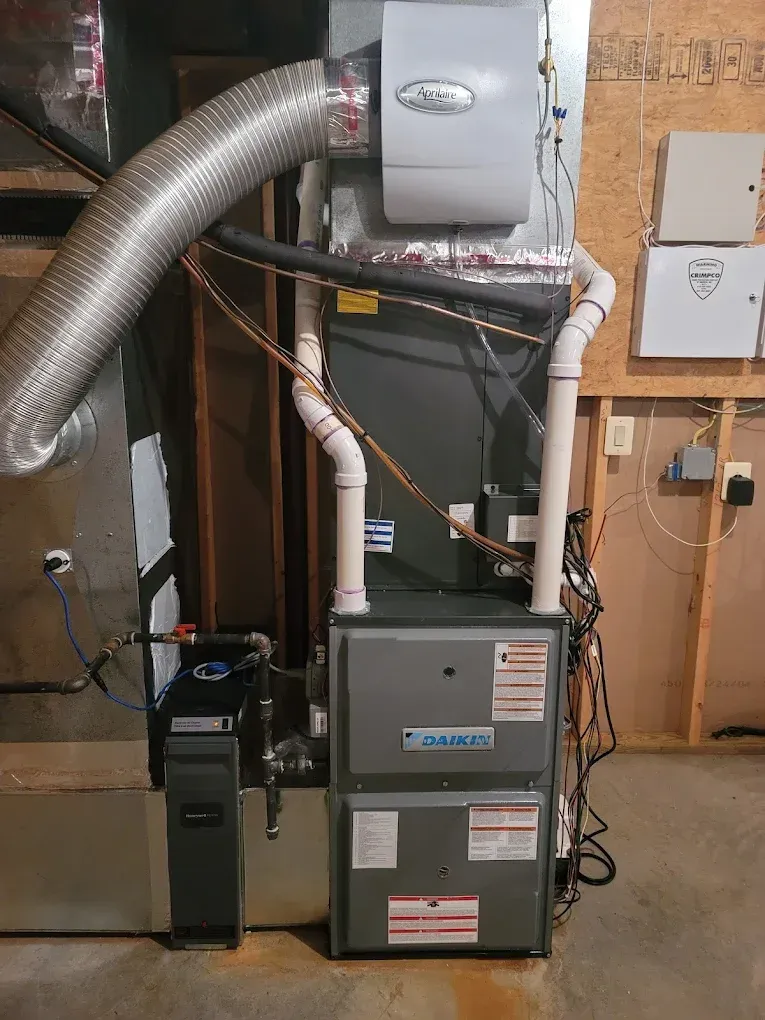 Furnace and HVAC equipment with silver ducting in a utility room basement