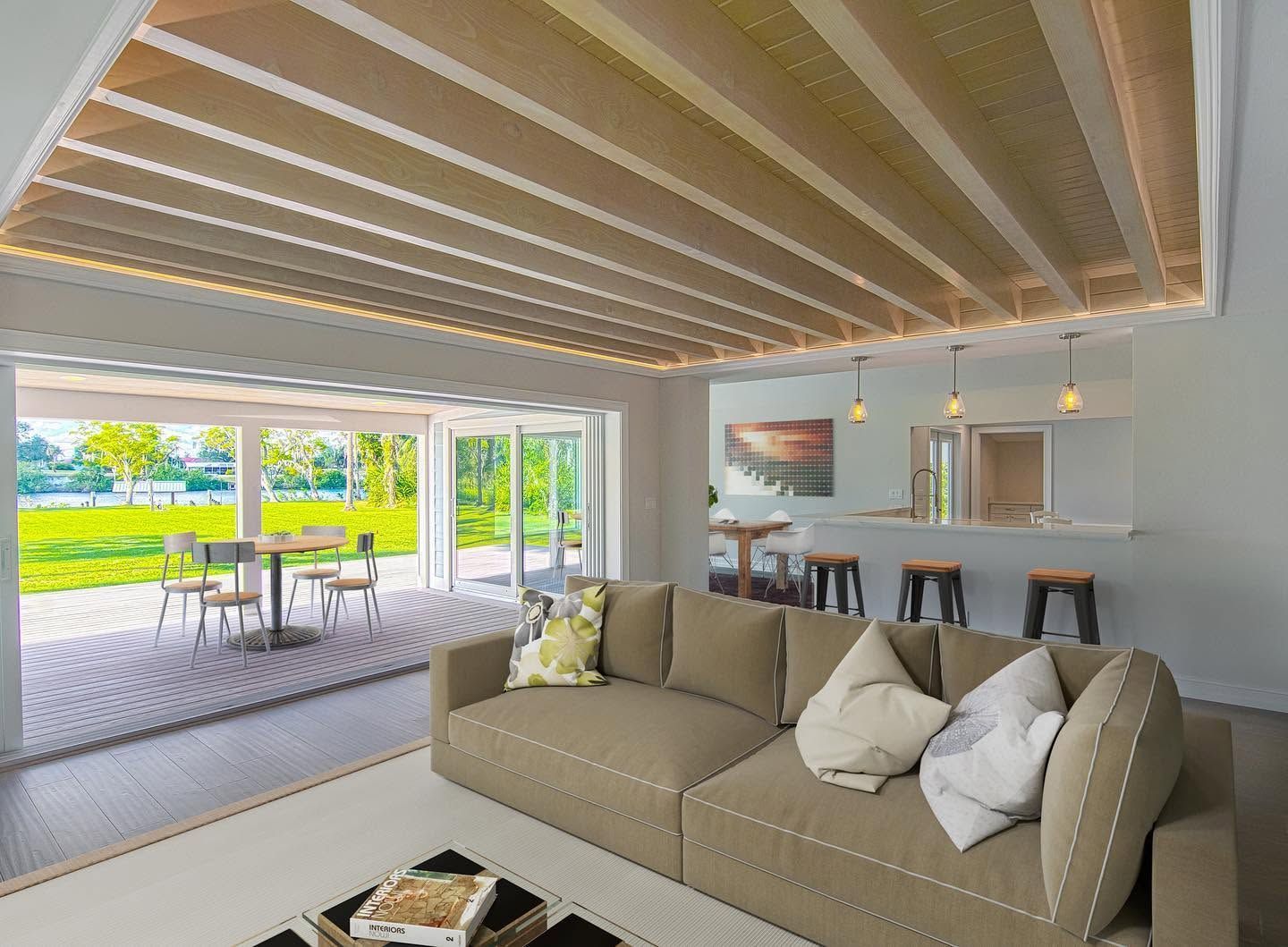 Modern living room with beige sofa, wood ceiling, bar seating, and open patio view