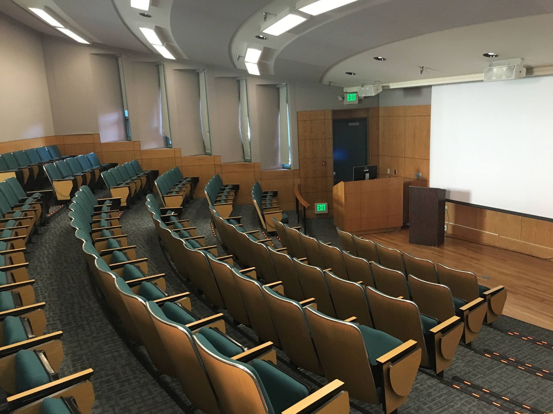 An auditorium with rows of chairs and a projector screen