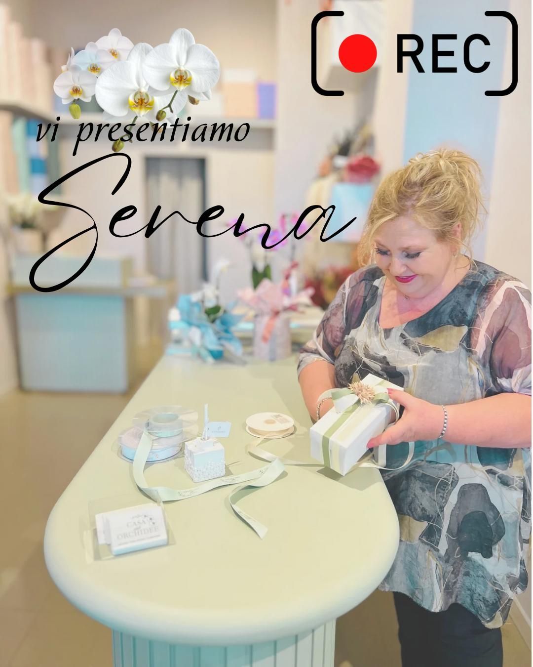 Donna che sistema scatole regalo attorno a un tavolo rotondo, con la scritta “vi presentiamo Serena” e una sovrapposizione REC.