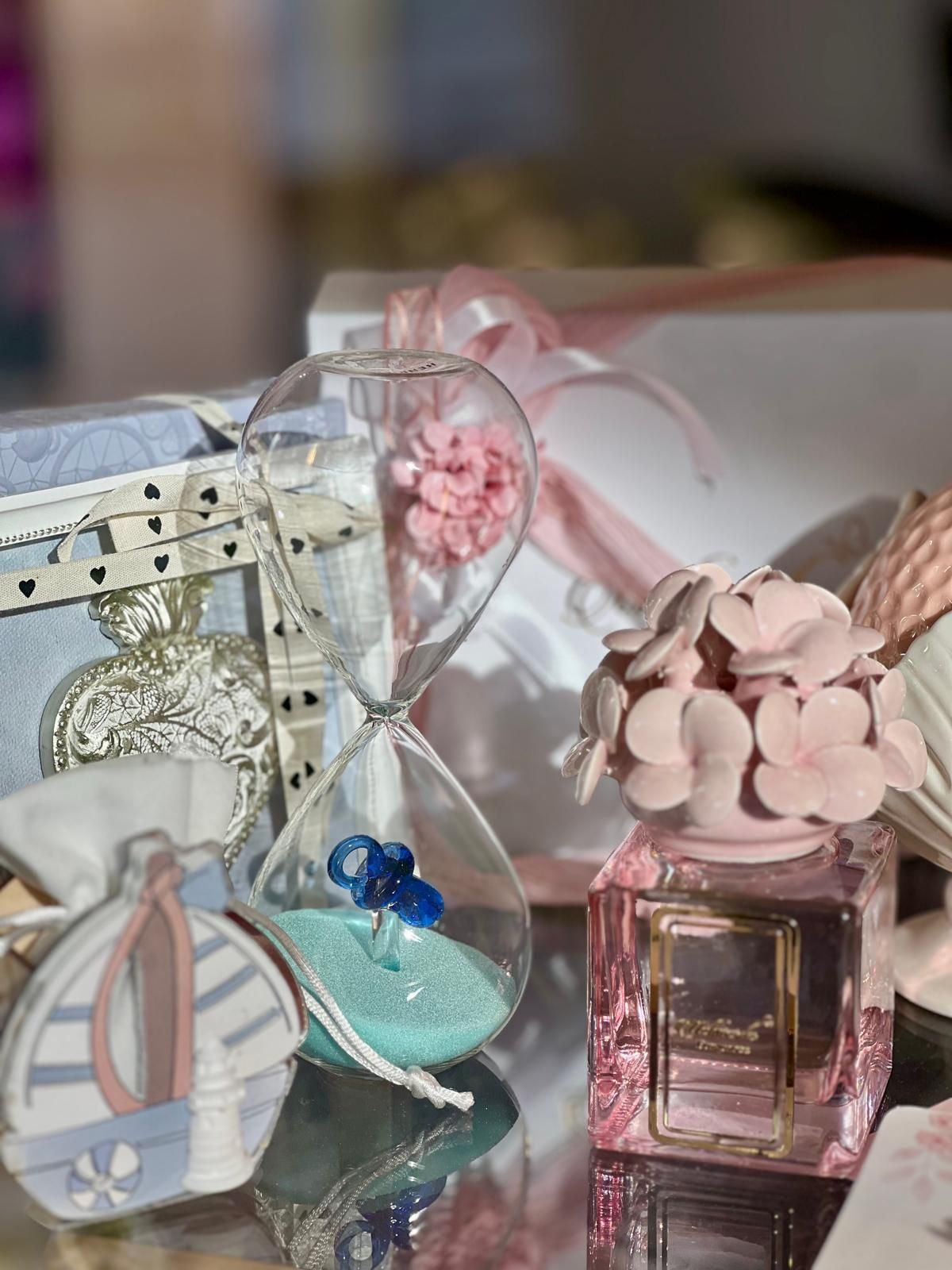 Flaconi di profumo decorativi color pastello con dettagli floreali su uno sfondo morbido e sfocato.