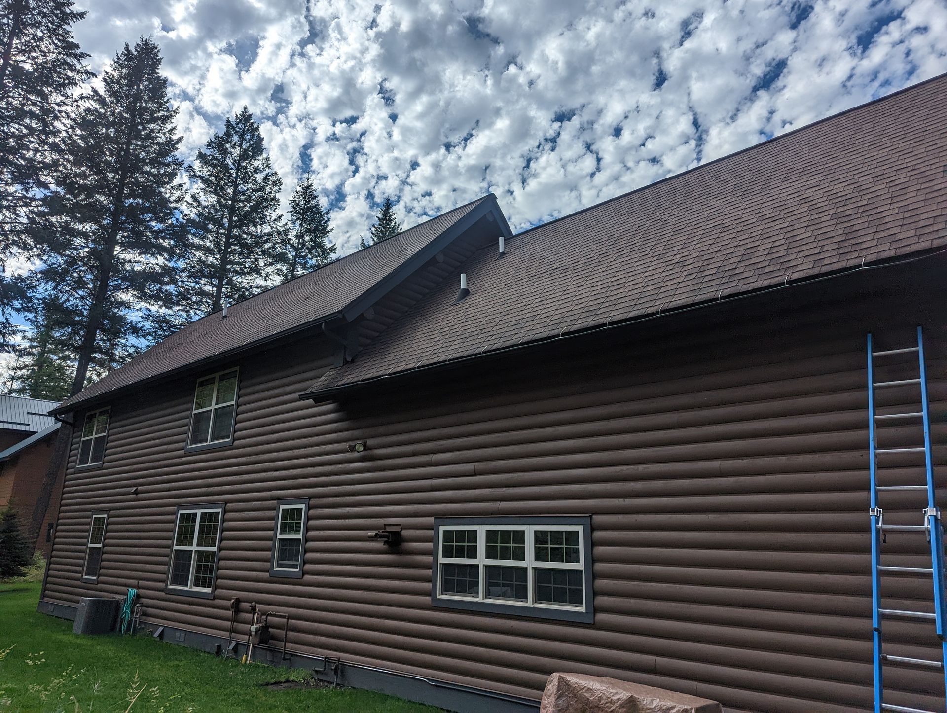 Person installing light green siding on a house exterior