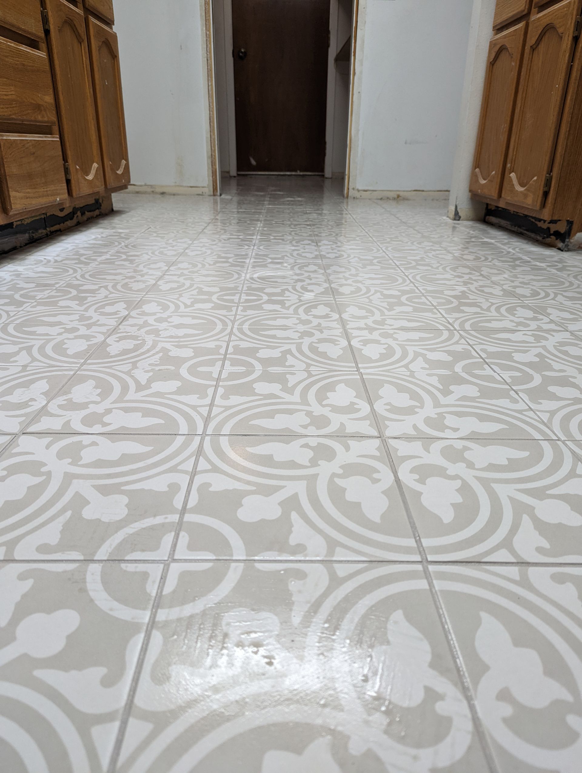 Worker installing wood-look floor tiles with adhesive spread on the subfloor