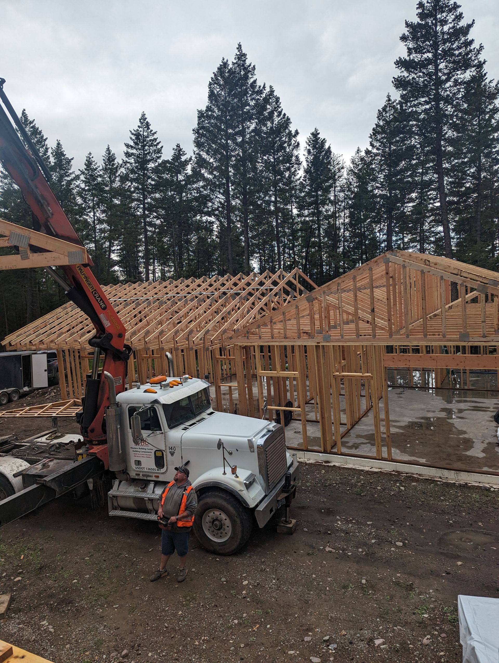House with scaffolding during exterior renovation, dark siding under a partly cloudy sky