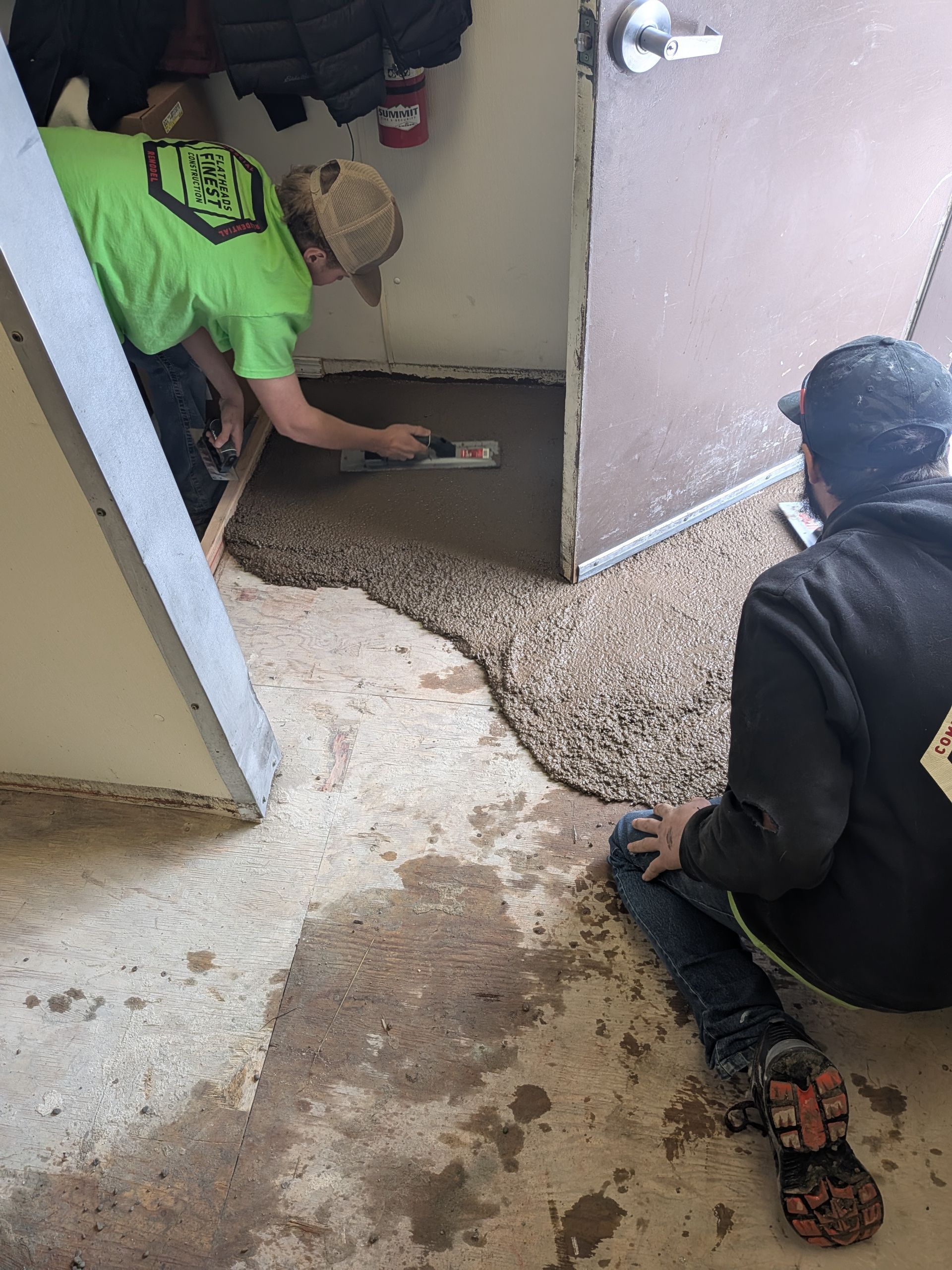 Construction worker shaking hands with client on a job site, holding a clipboard