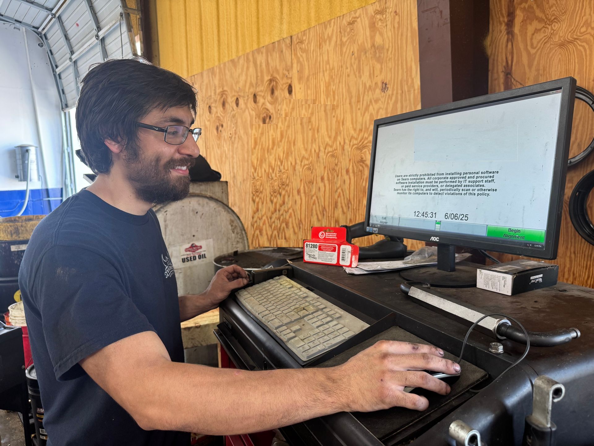 Person using a handheld keyboard at a workstation with a monitor in a workshop setting