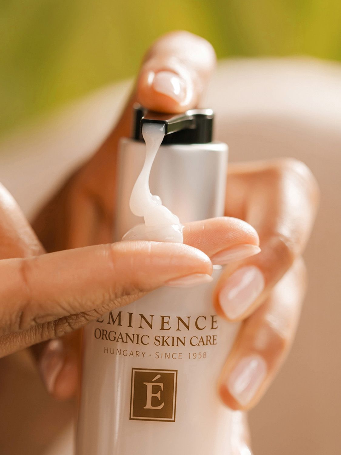 Bottle of cleansing milk with a pump dispenser, white label, silver accents, and black pump top.