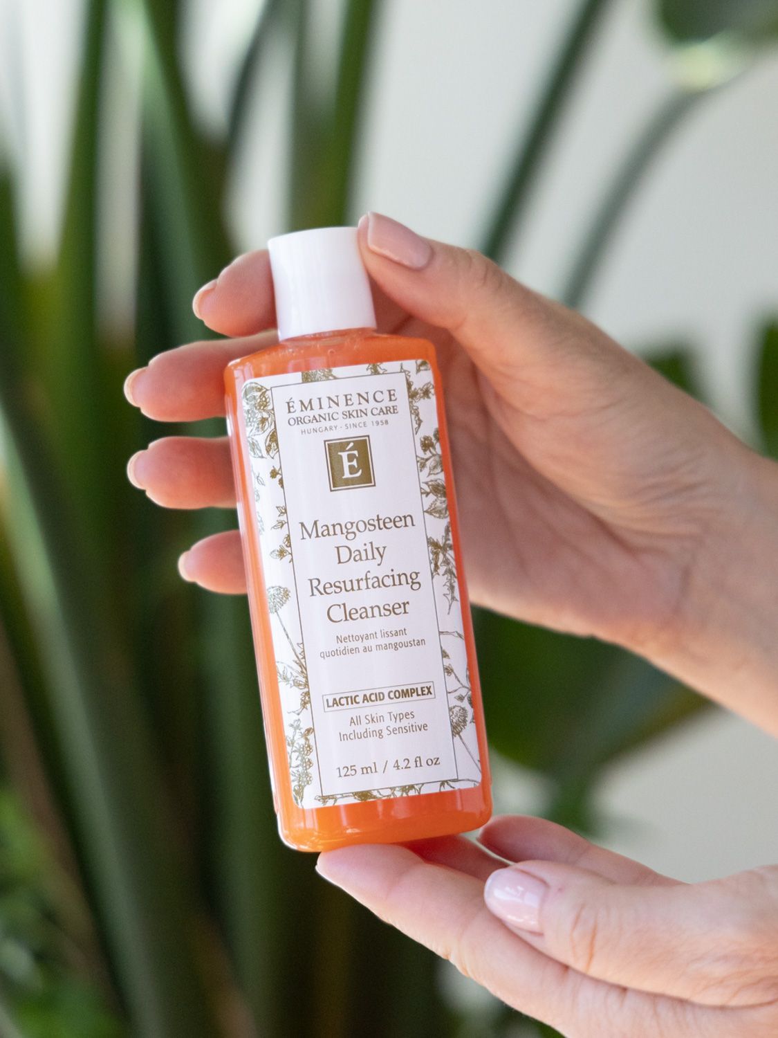 Orange bottle of Eminence Mangosteen Daily Resurfacing Cleanser with white cap.