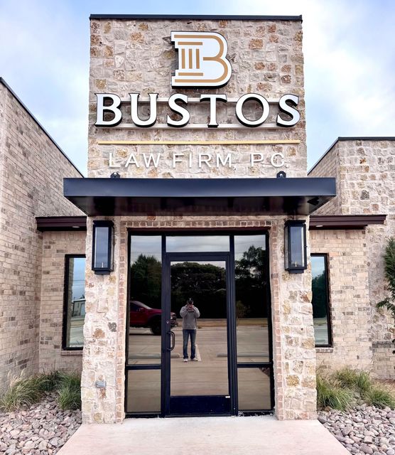A man is standing in front of a bustos law firm