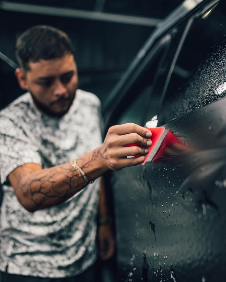 Two men are working on a car in a garage.
