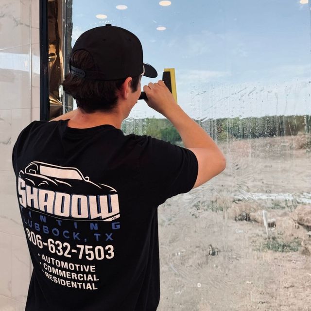 A man wearing a black shirt that says shadow on it