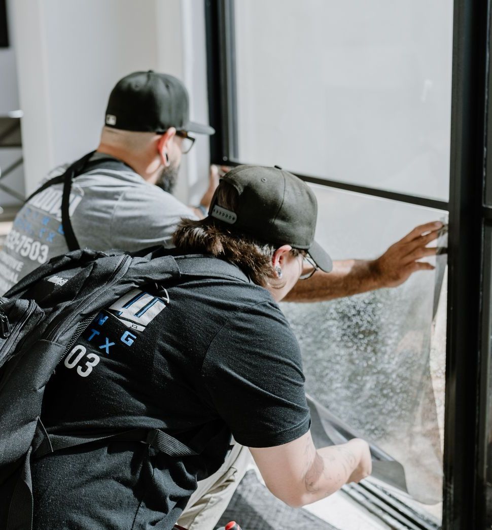A man with a backpack on his back is cleaning a window.
