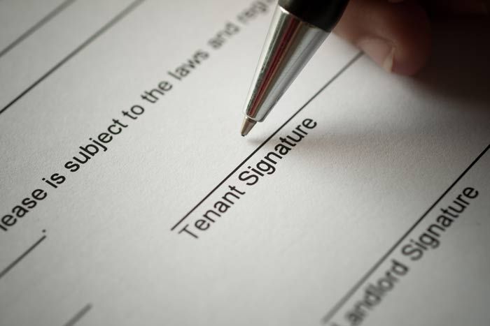 Pen signing a tenant signature line on a legal form