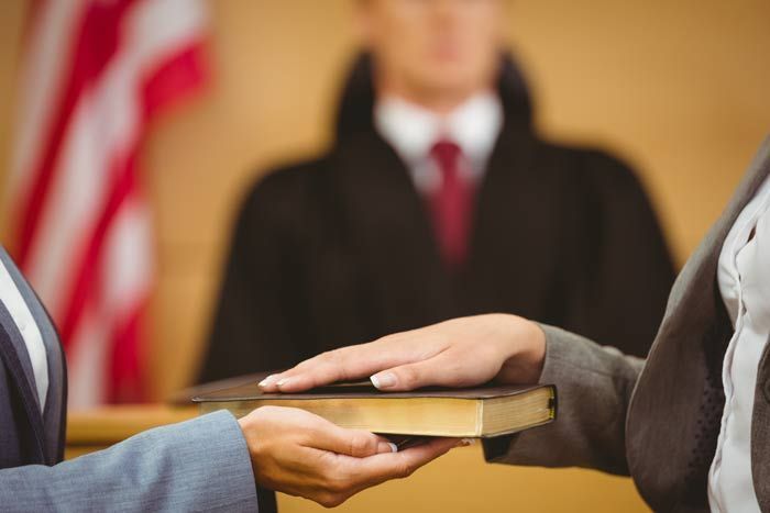 Handing over a book during a formal oath ceremony, with an American flag in the background