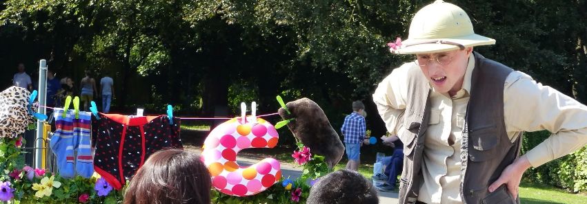 Prof. Mappinton telling a story to a family audience in a park.