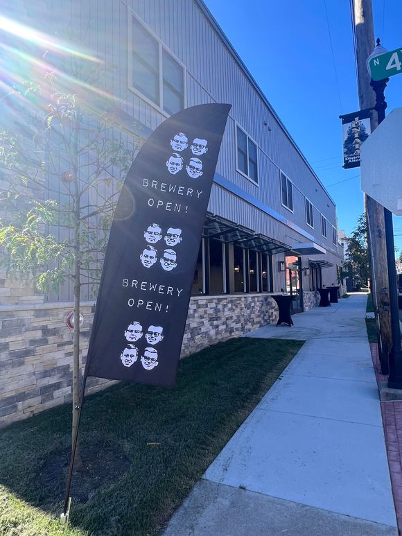 Flag outside a modern building, with text. Sunny day, street view.