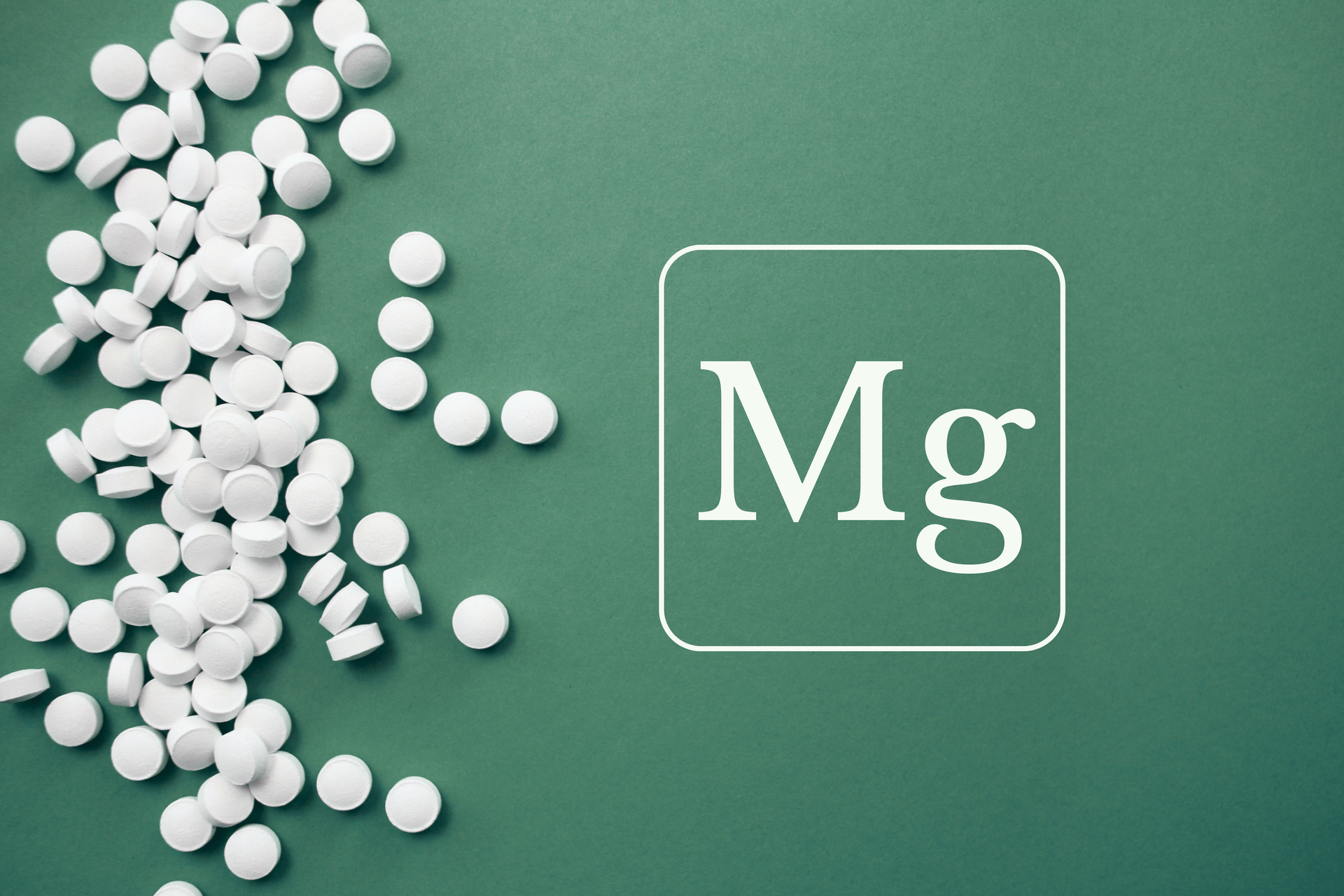 White tablets beside a green box labeled “Mg” on a green background