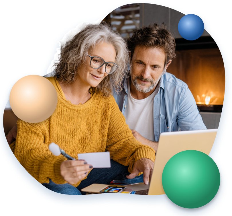 Mature couple reviewing documents and using a laptop at home, woman holding a credit card.