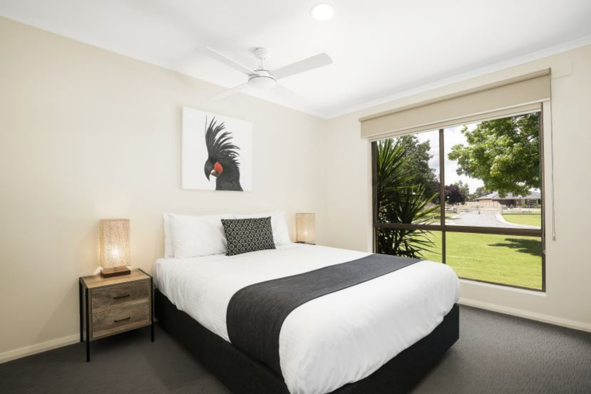 A bedroom with a king size bed and a ceiling fan.