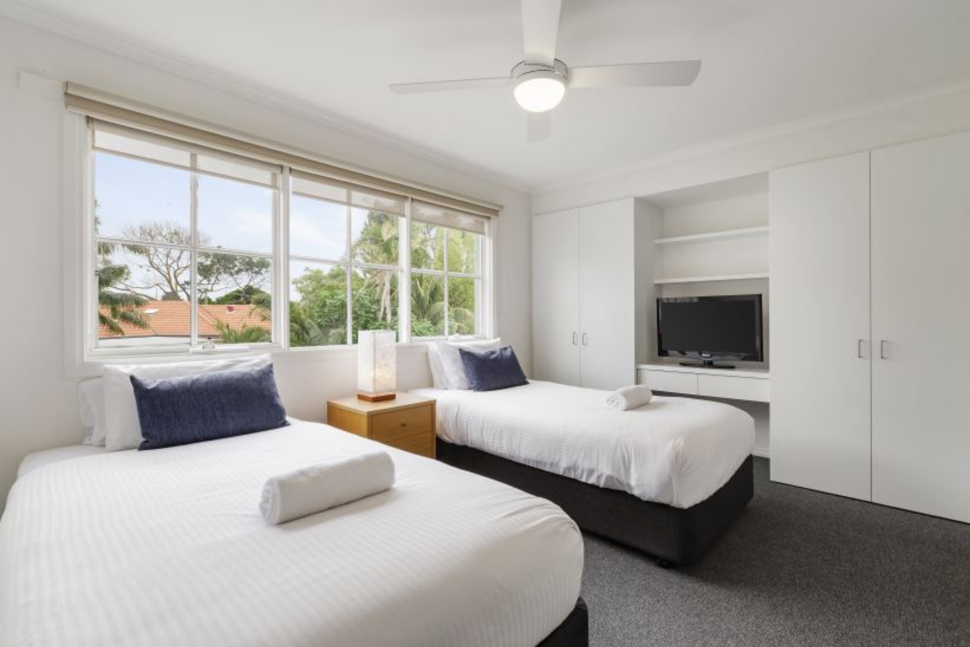 A hotel room with two beds and a ceiling fan.