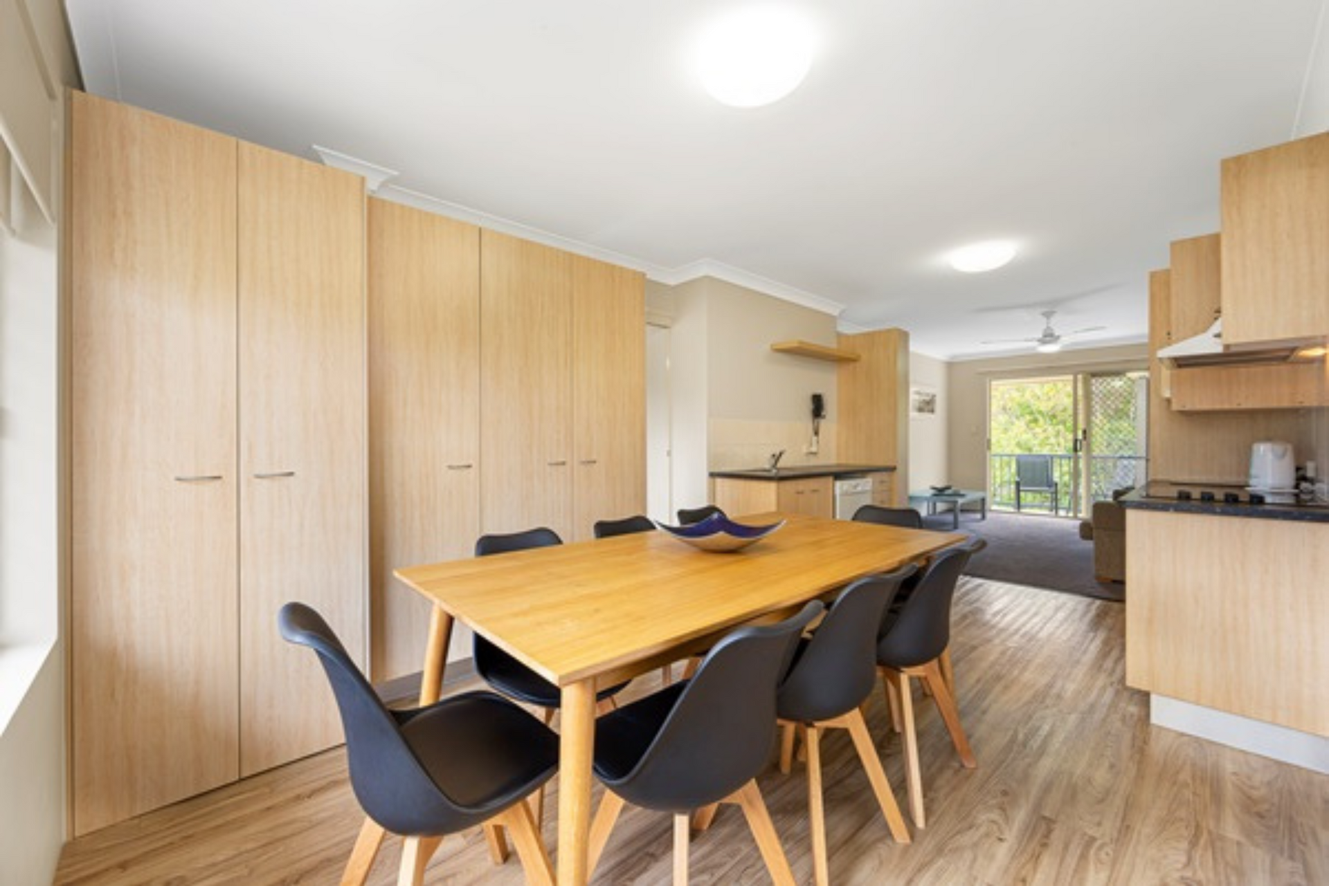 A dining room with a wooden table and black chairs.