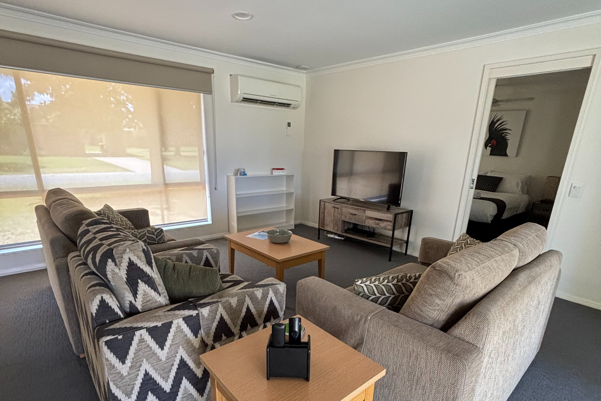 A living room with a couch , chair , table and television.