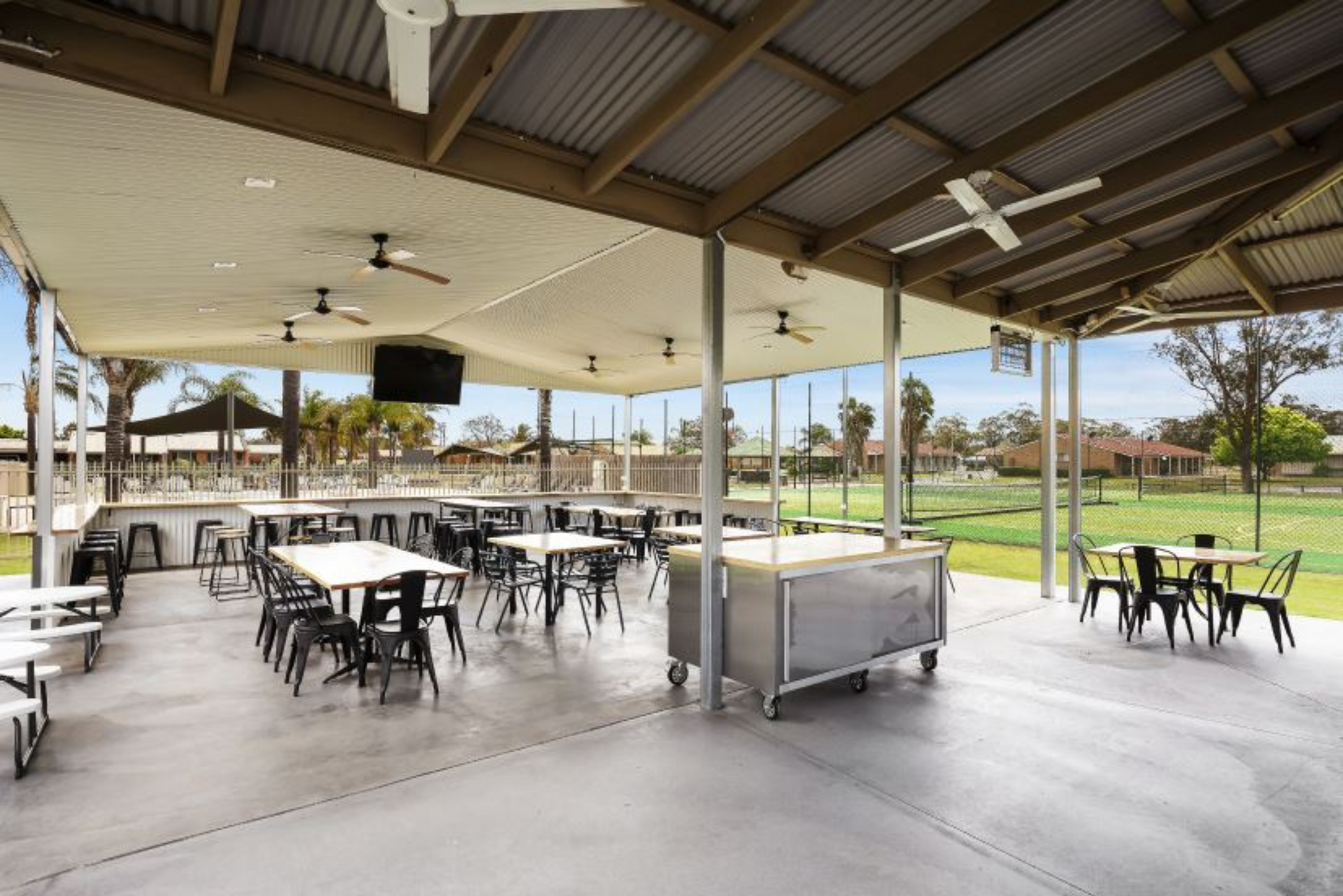 A large covered area with tables and chairs under a roof.