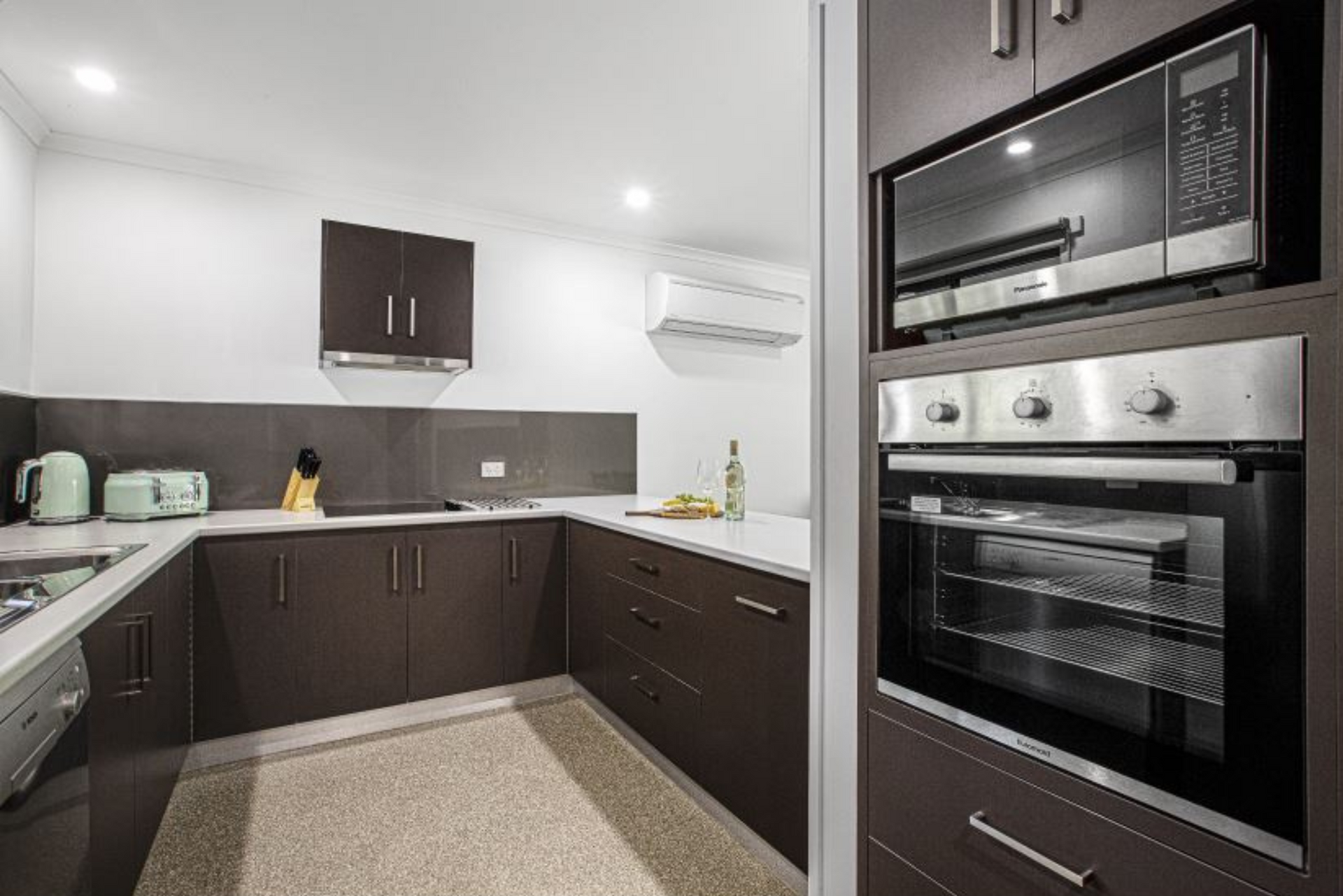 A kitchen with stainless steel appliances and brown cabinets.