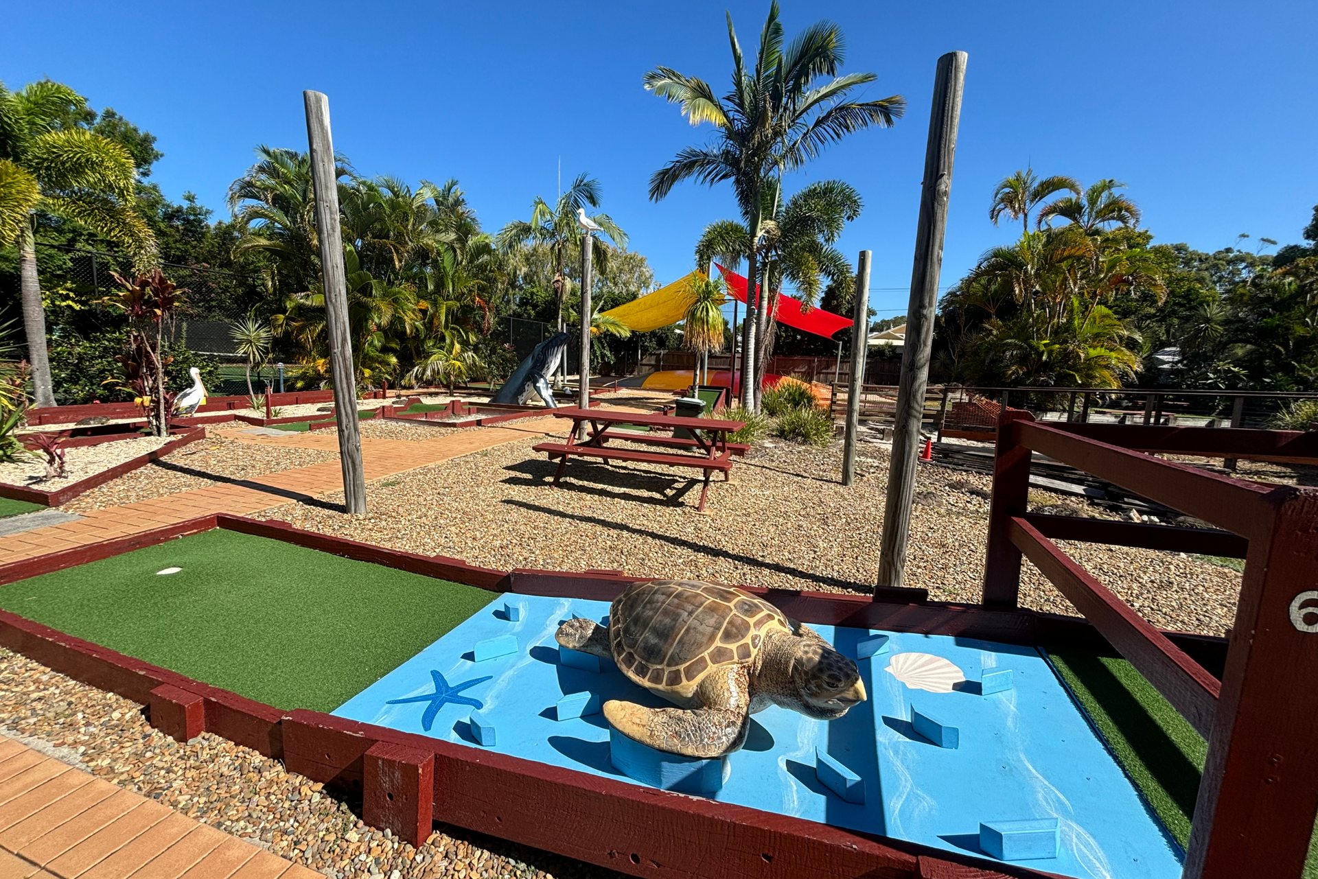 A turtle is sitting on top of a small golf course.