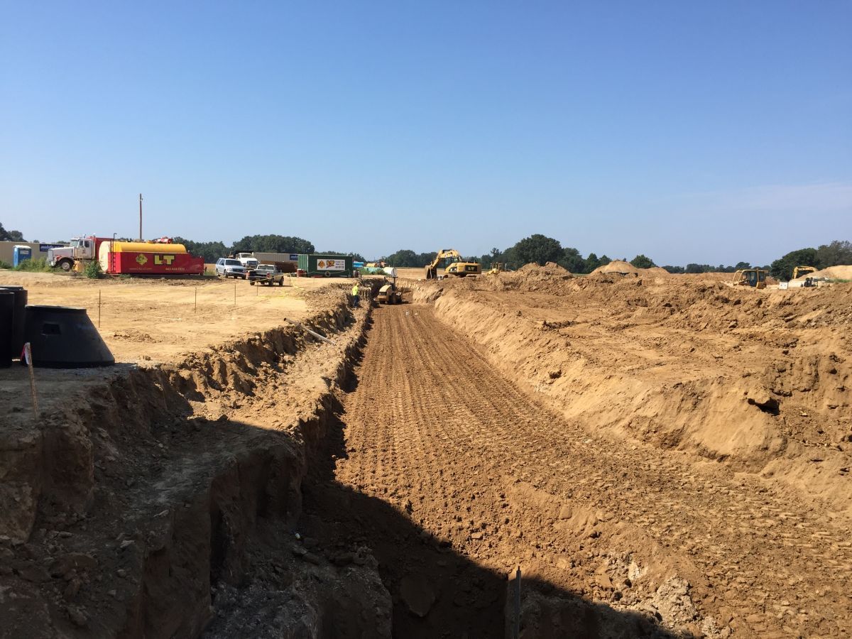 A large pile of dirt is being excavated in a field.