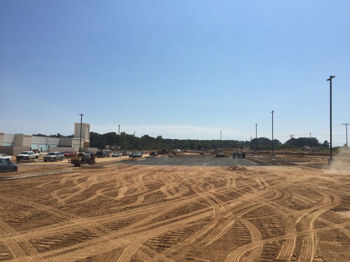 A construction site with a lot of dirt and a blue sky in the background.