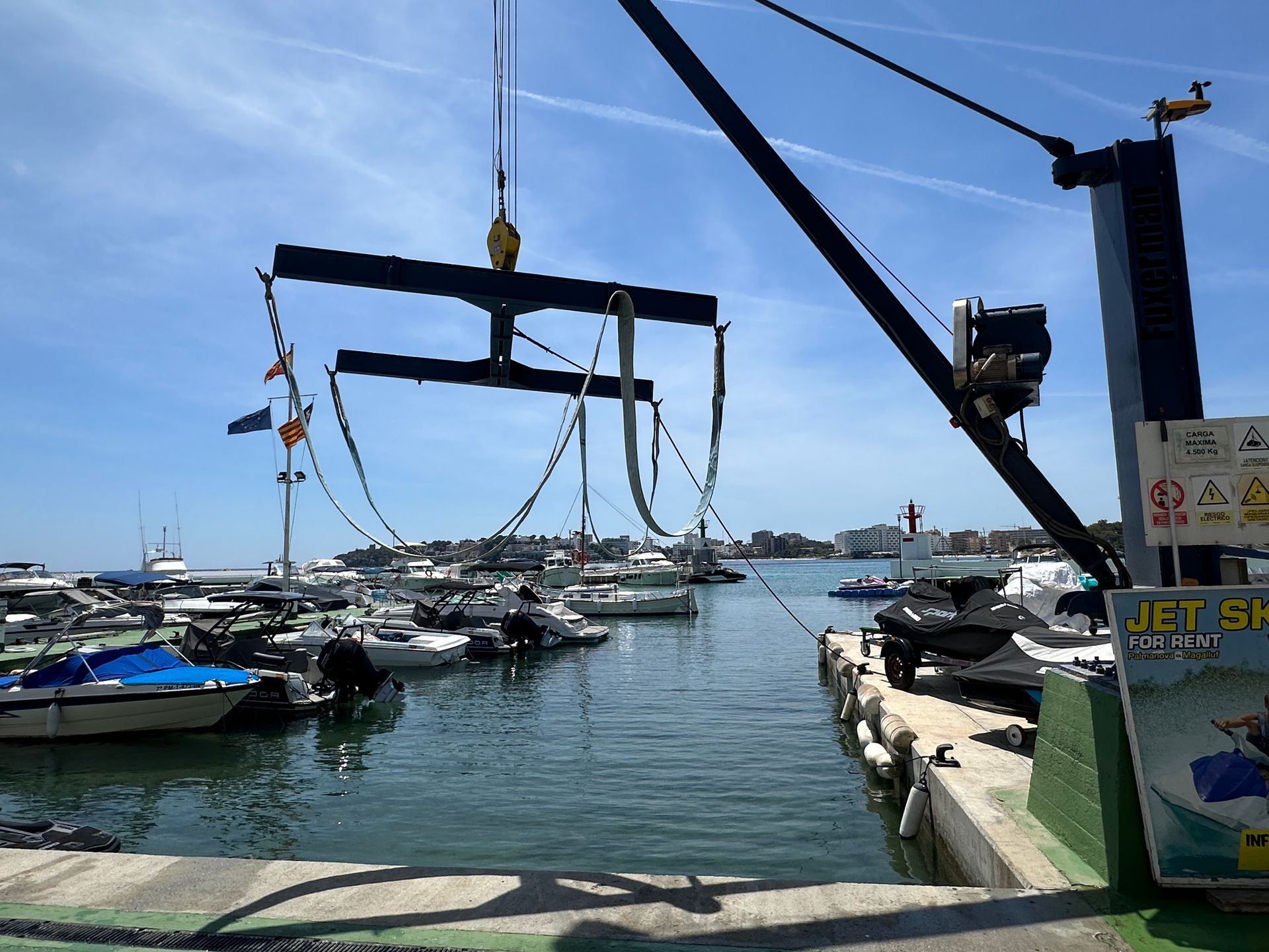 Una grúa levanta una moto acuática en un puerto deportivo
