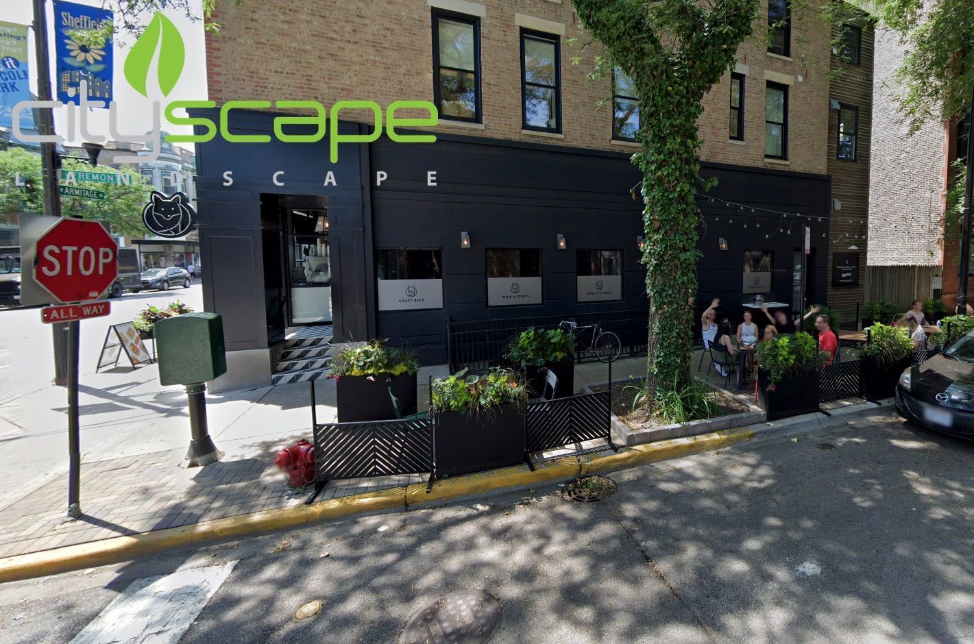 Exterior view of Cityscape, a black-painted restaurant with outdoor seating. A stop sign is in the foreground.
