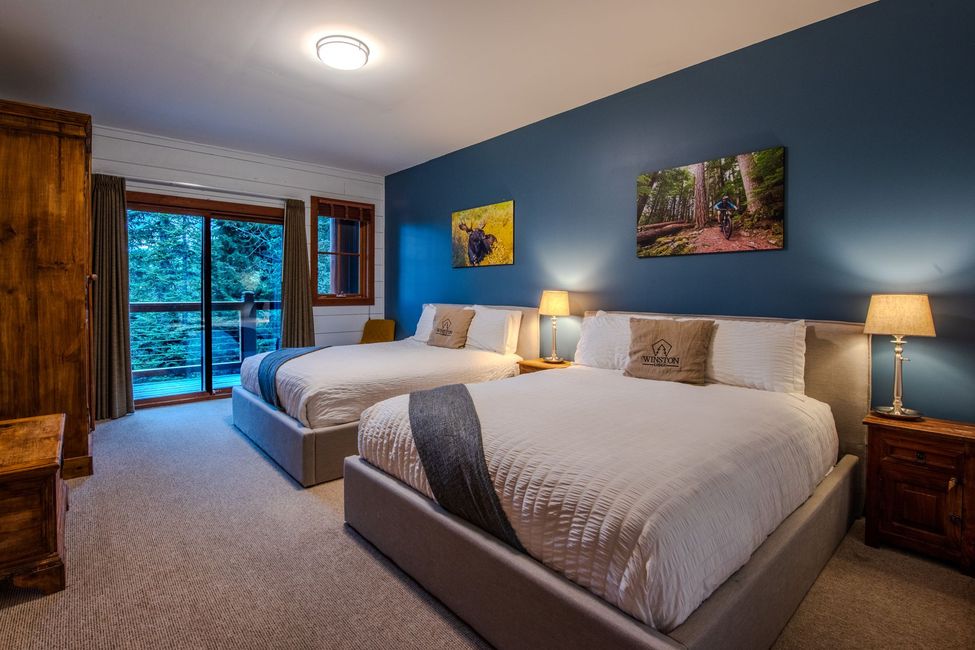 A hotel room with two beds and a balcony.